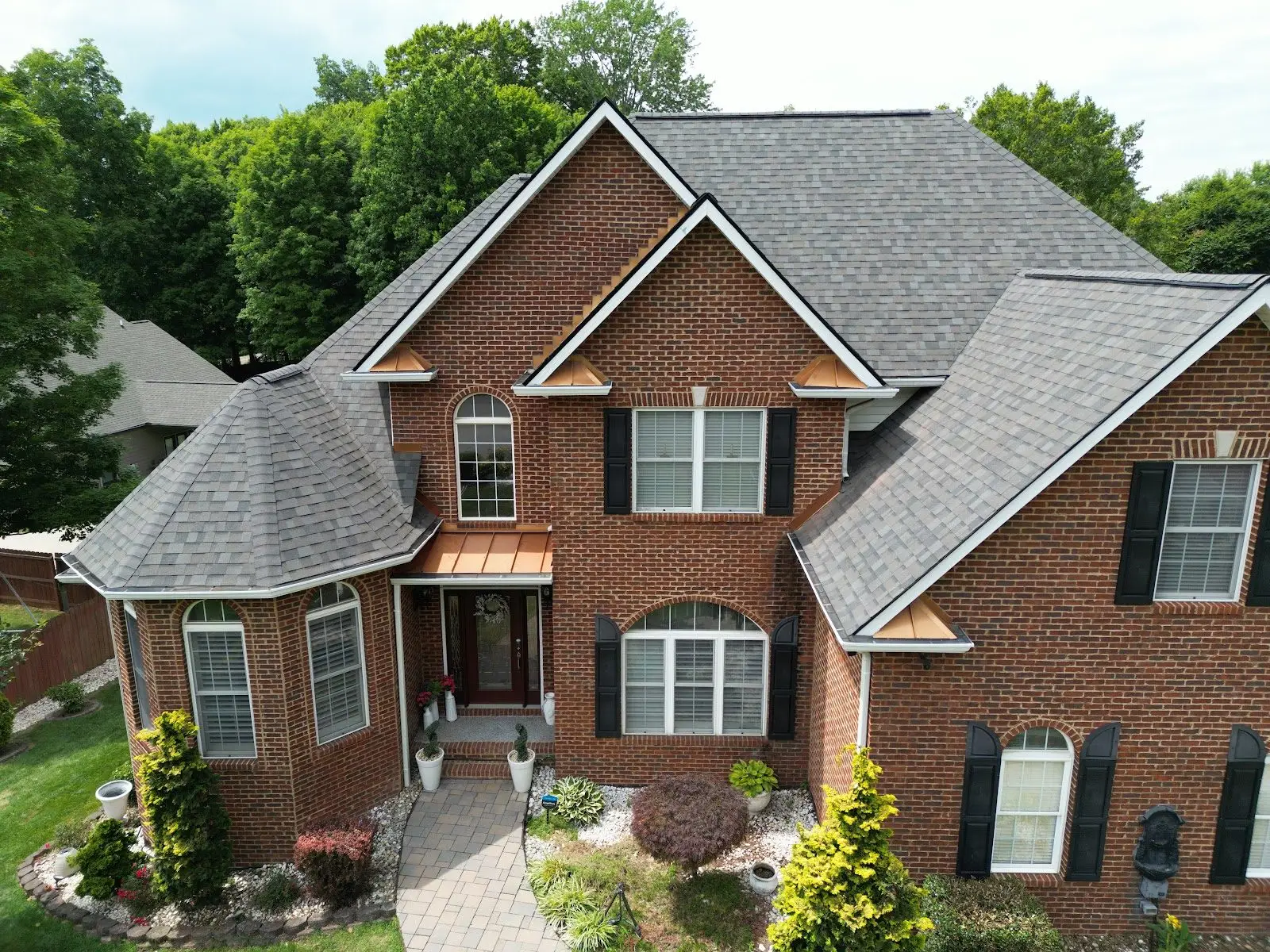 New architectural shingle roof on a red brick home with copper accents in Johnson City, TN